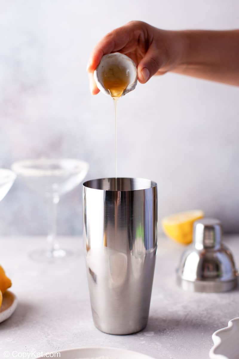 pouring agave syrup into a cocktail shaker