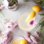 overhead view of a lemon drop martini, lemons, and flowers