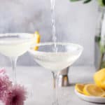 pouring a lemon drop martini into a sugar rimmed glass