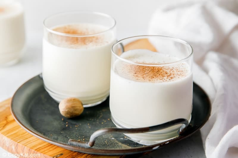 two glasses of milk punch on a round black tray