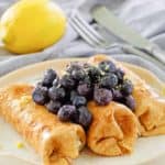 cheese blintz topped with blueberries on a plate