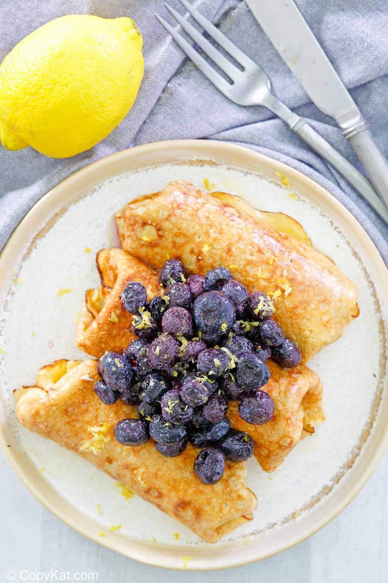 overhead view of the cheese blintz topped with blueberries.