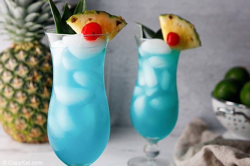 two homemade Olive Garden Blue Hawaiian drinks and a pineapple