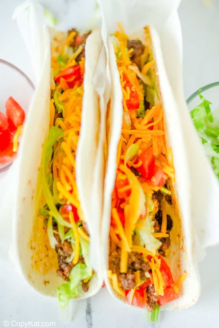 two homemade Taco Bell soft tacos with beef, lettuce, cheese, and tomatoes