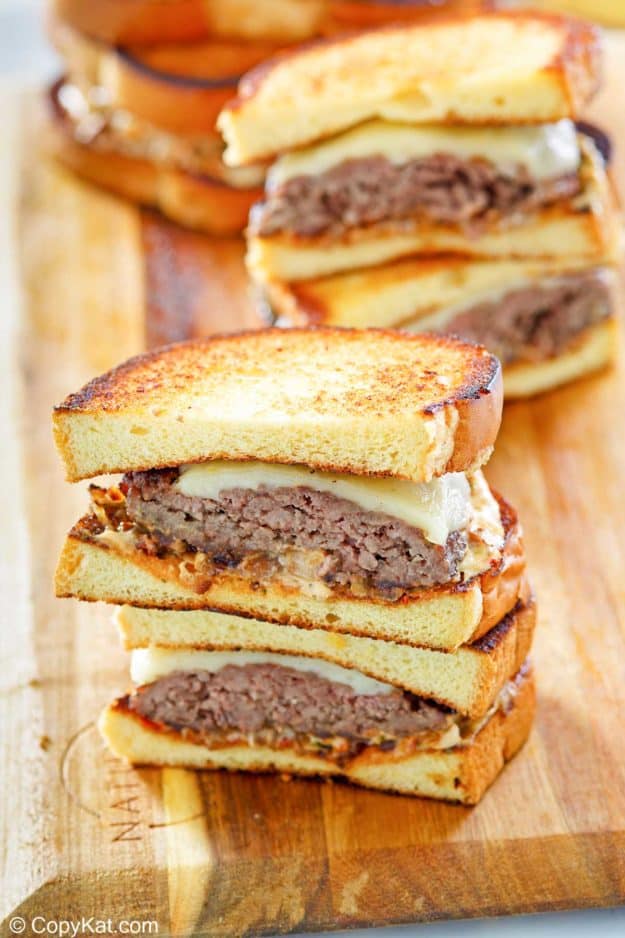 homemade Whataburger patty melt sandwiches on a wood board