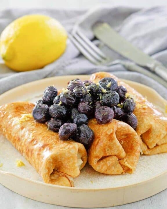 cheese blintz topped with blueberries on a plate