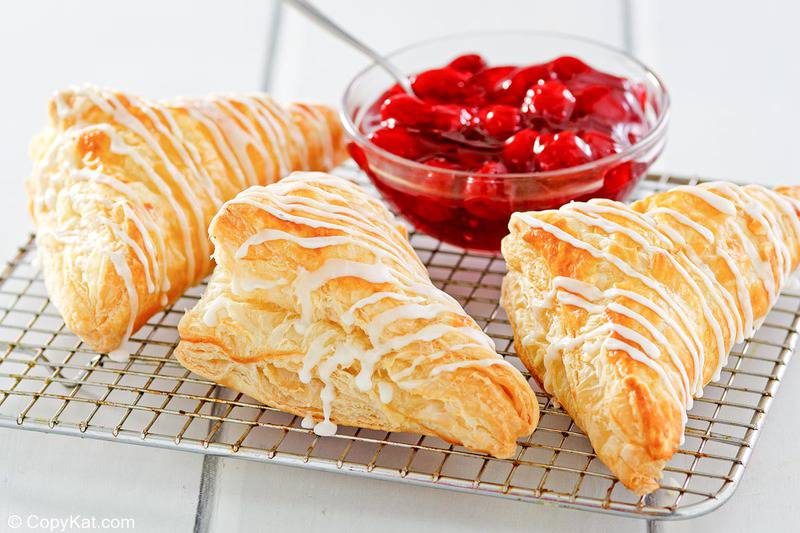 three homemade Arby's cherry turnovers on a wire rack