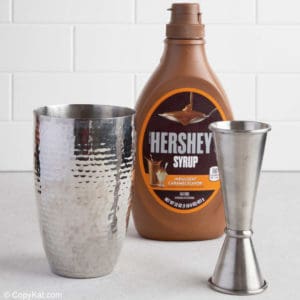 Hershey's caramel syrup bottle, cocktail shaker, and jigger