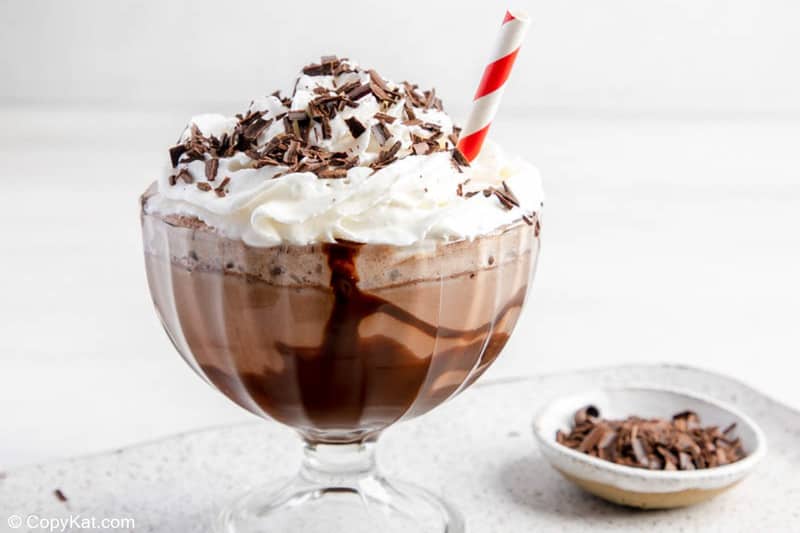 frozen hot chocolate in a large glass and chocolate shavings in a small bowl.