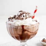 frozen hot chocolate with whipped cream and chocolate shavings in a large glass.