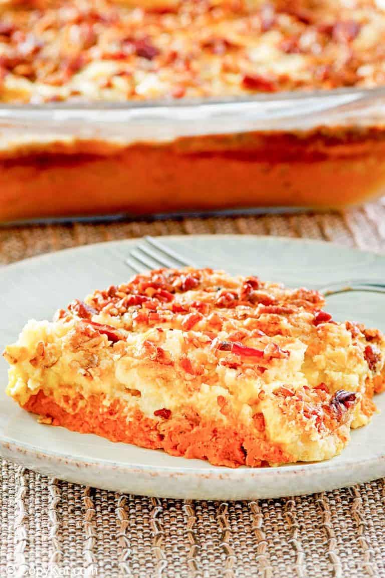 pumpkin dump cake slice on a plate in front of the cake
