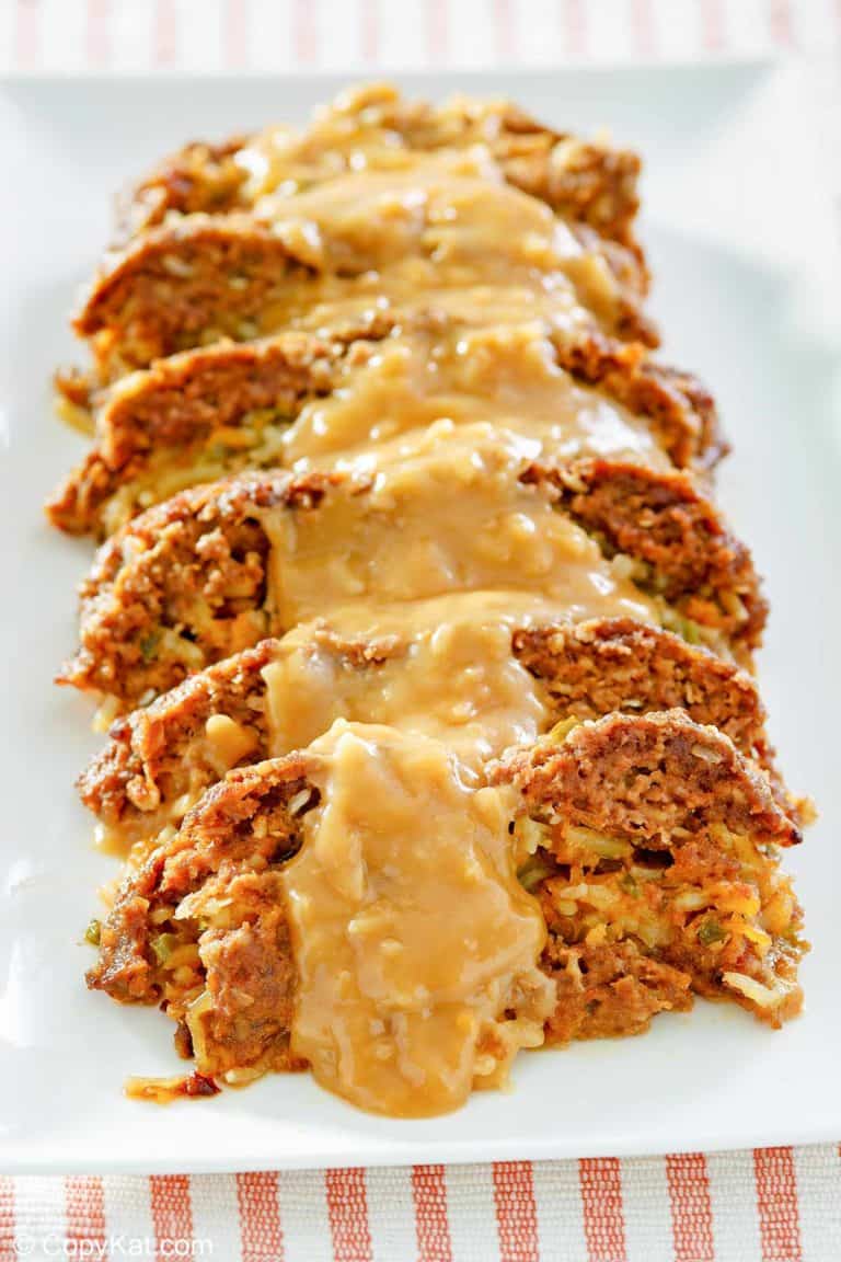 sliced of stuffed meatloaf with gravy on a platter