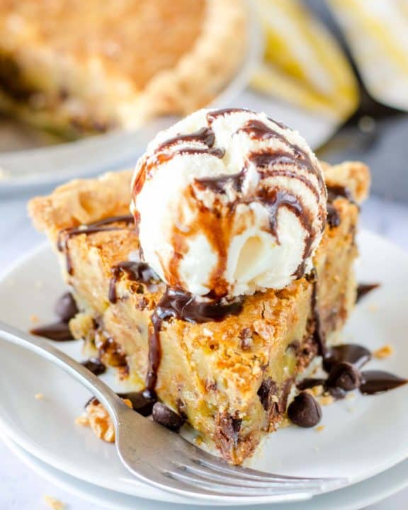 a slice of Toll House pie topped with ice cream and chocolate syrup