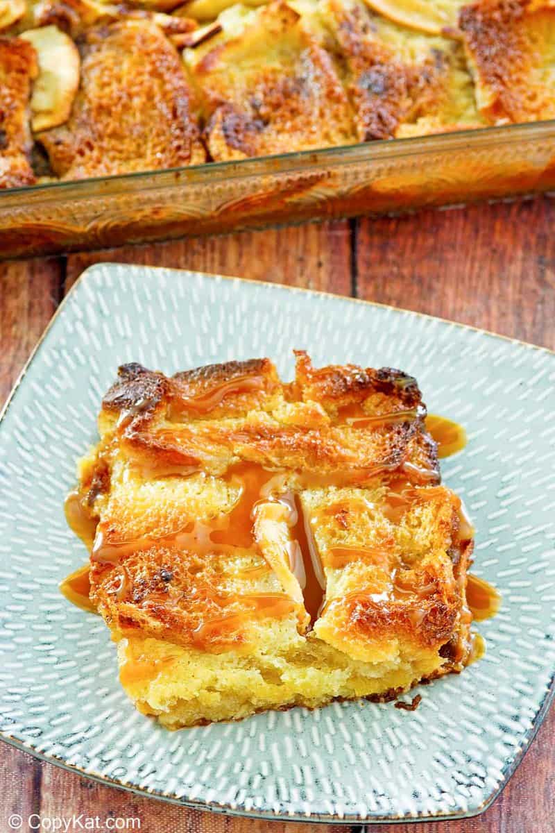 apple bread pudding topped with caramel sauce on a plate.