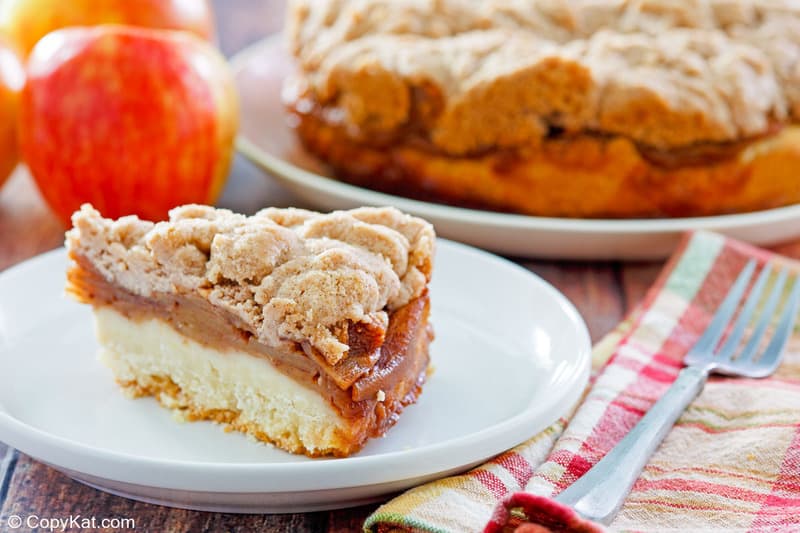 apple coffee cake with crumb topping slice on a plate.