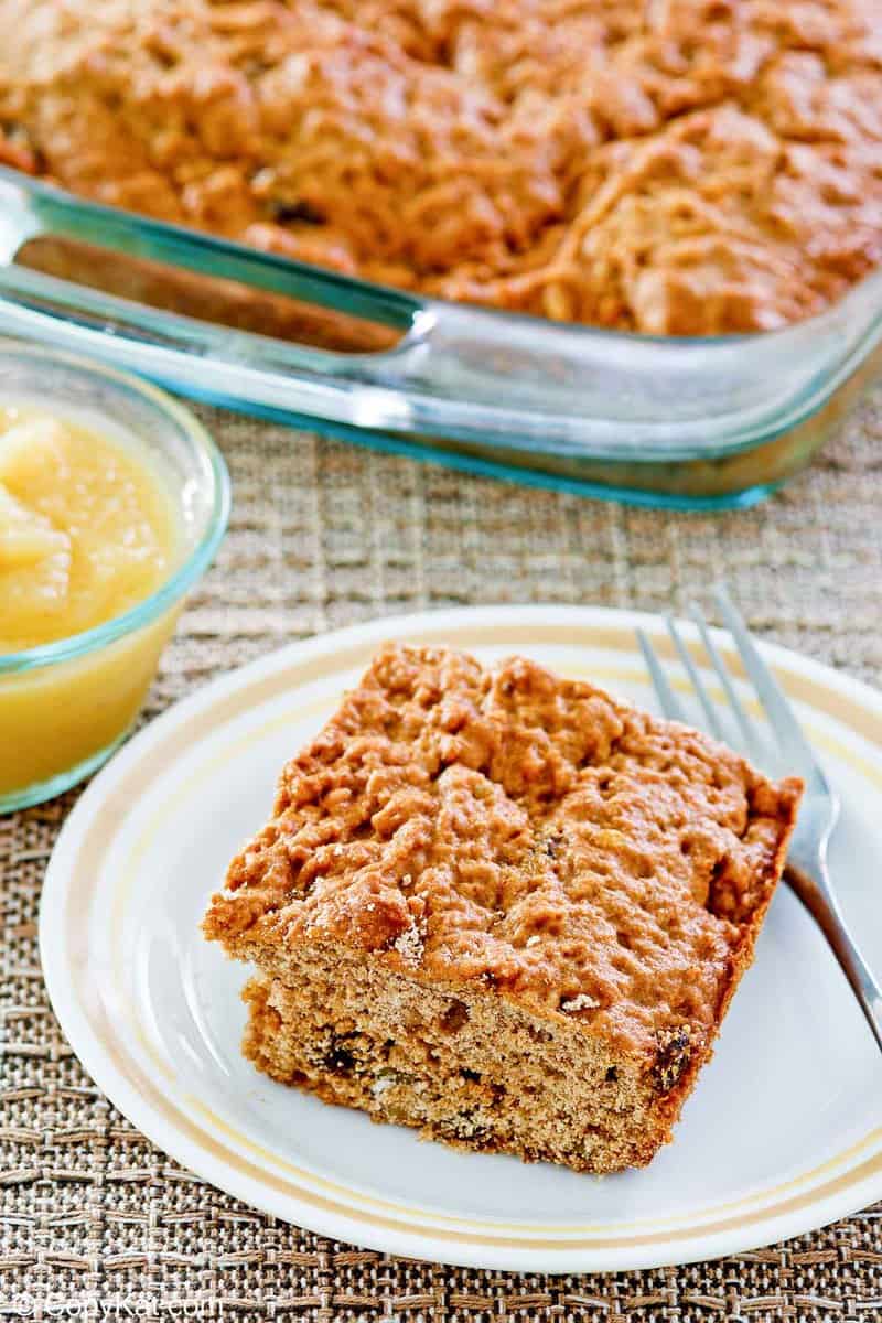 applesauce cake slice on a plate and the cake in a glass baking dish.