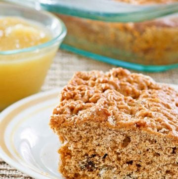 a slice of applesauce cake on a plate and applesauce in a small bowl.