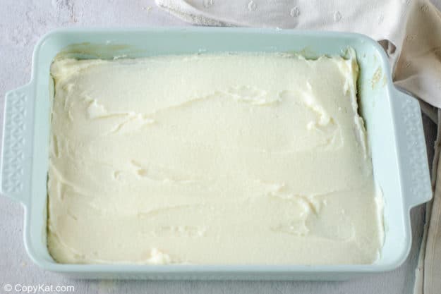 banana cake with cream cheese frosting in a baking dish.