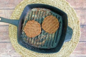 two cooked beyond burger patties in a grill pan.