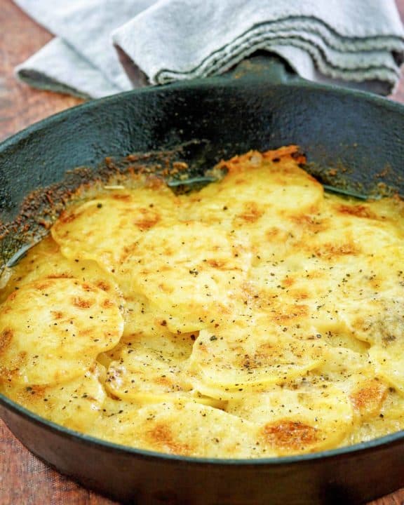 cheesy potatoes au gratin in a skillet.