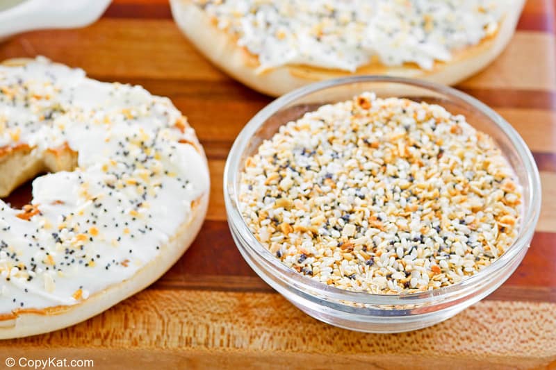 homemade everything bagel seasoning in a small bowl on a board with bagels.
