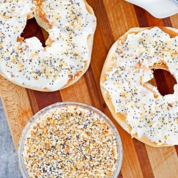 a bowl of homemade everything bagel seasoning and a bagel with cream cheese.