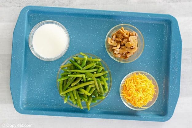 green bean casserole with cheese ingredients on a tray.