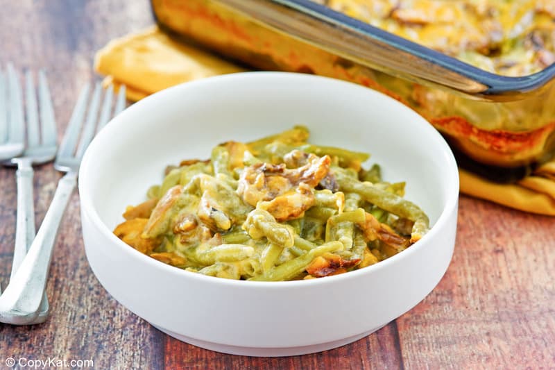 bowl of green bean casserole with cheese and two forks.