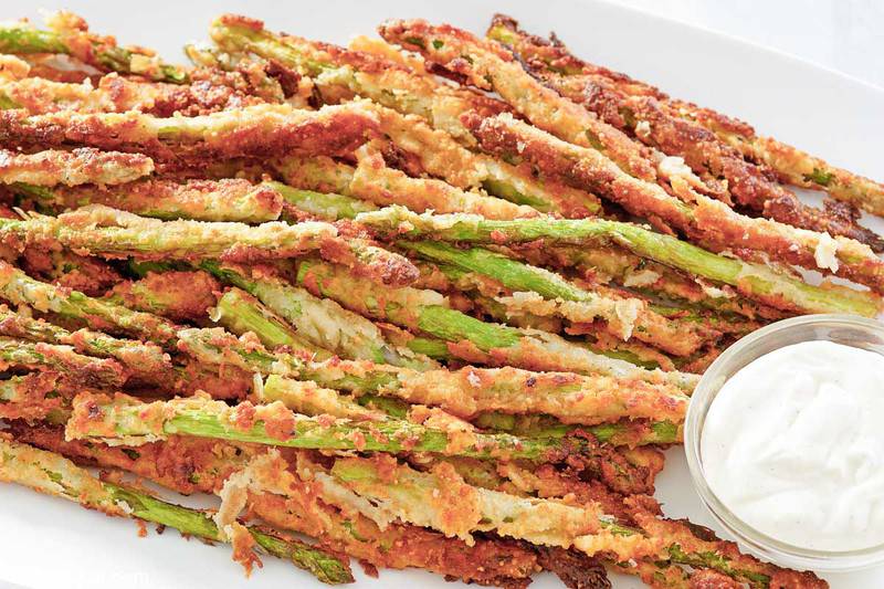 homemade Longhorn Steakhouse parmesan crusted asparagus and a small bowl of ranch sauce.