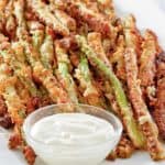 homemade Longhorn parmesan crusted asparagus and ranch sauce on a platter.