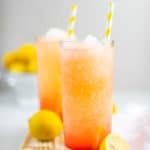 two glasses of homemade McDonald's frozen strawberry lemonade on a wood board.