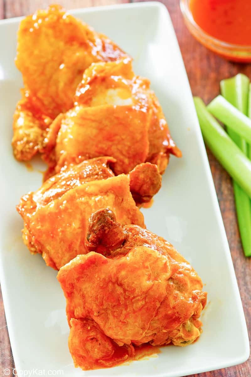 homemade Wingstop Buffalo chicken thighs, celery sticks, and Buffalo sauce.