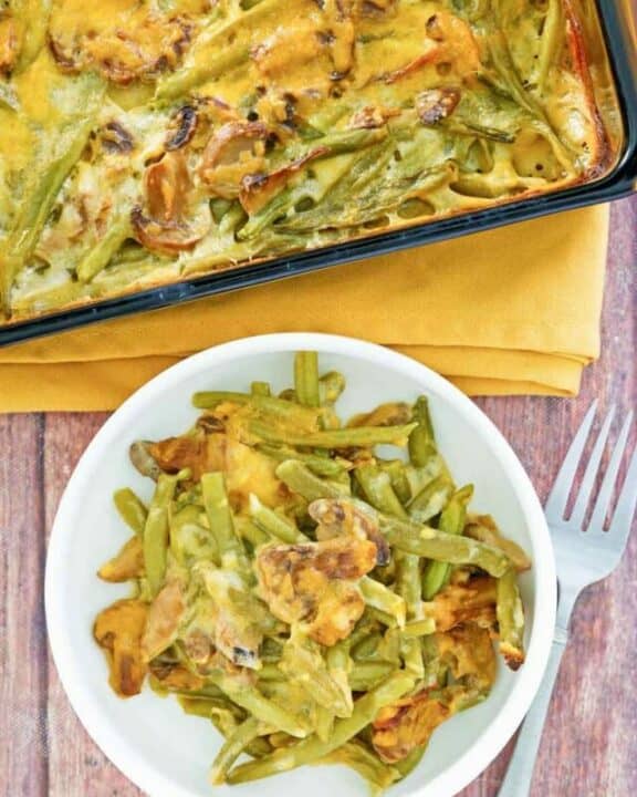 overhead view of green bean casserole with cheese in a baking dish and on a plate.