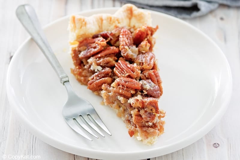 homemade Karo pecan pie slice and a fork on a plate.