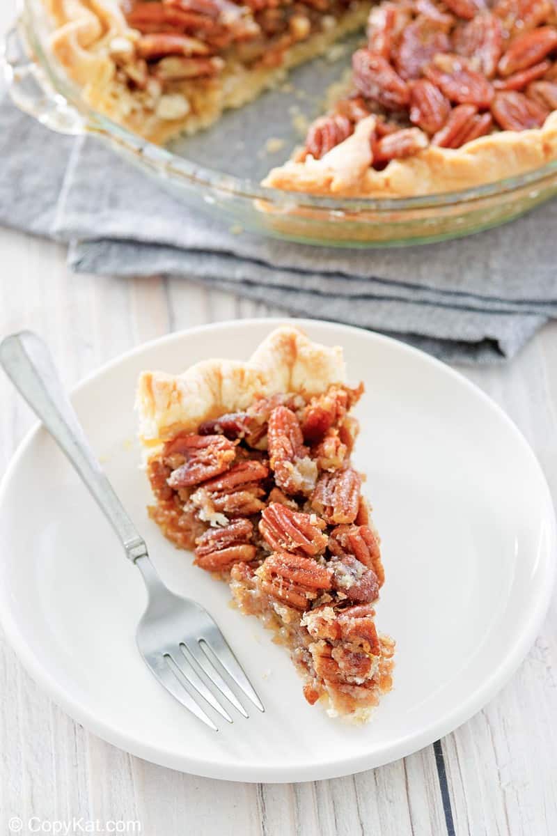 a slice of homemade Karo pecan pie and a fork on a plate.