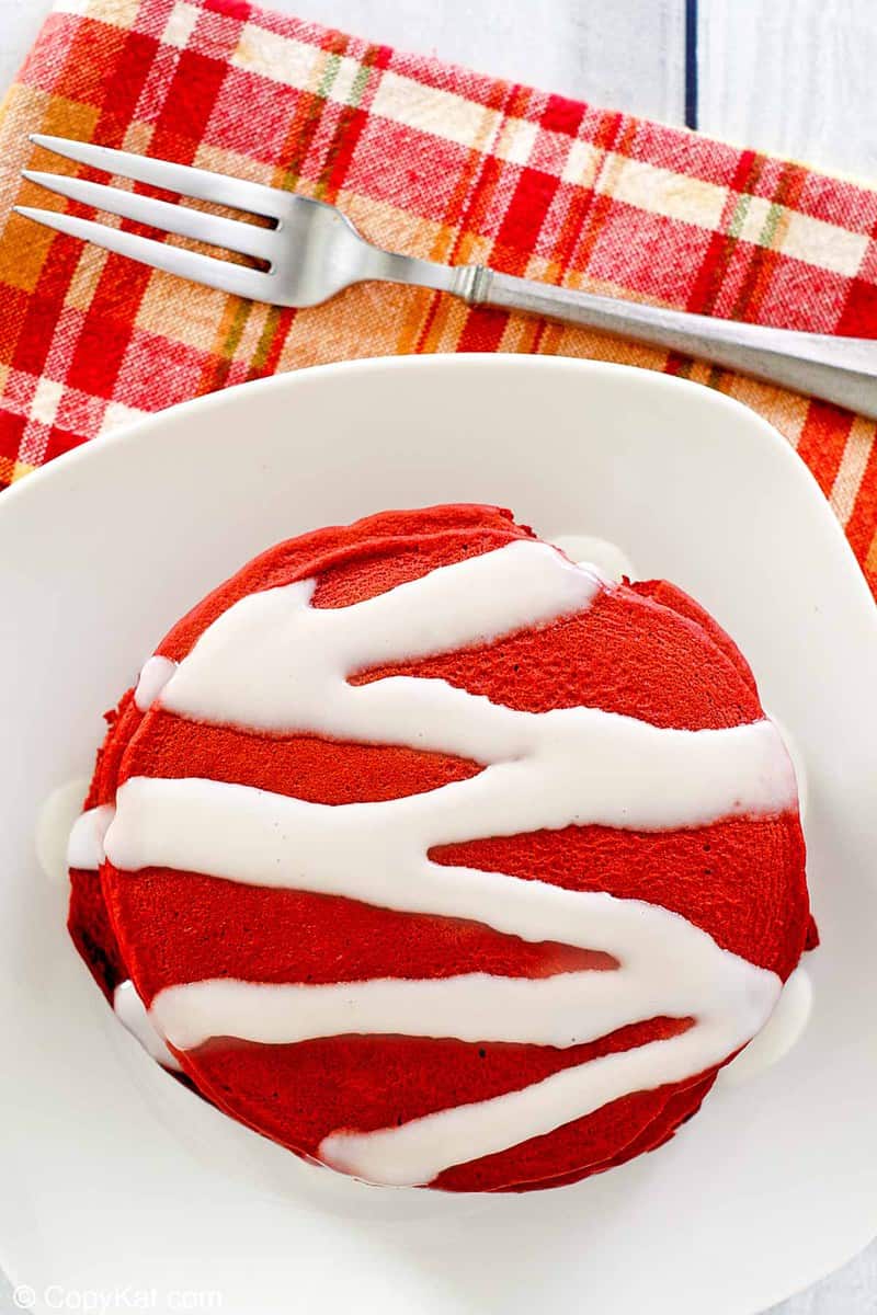 overhead view of red velvet pancakes with cream cheese glaze.