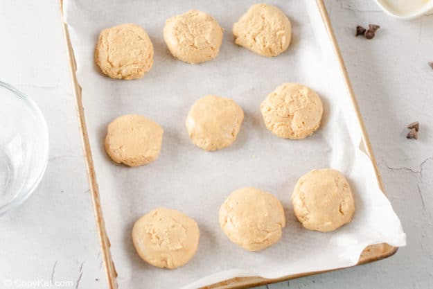 peanut butter patties on a parchment paper lined baking sheet.