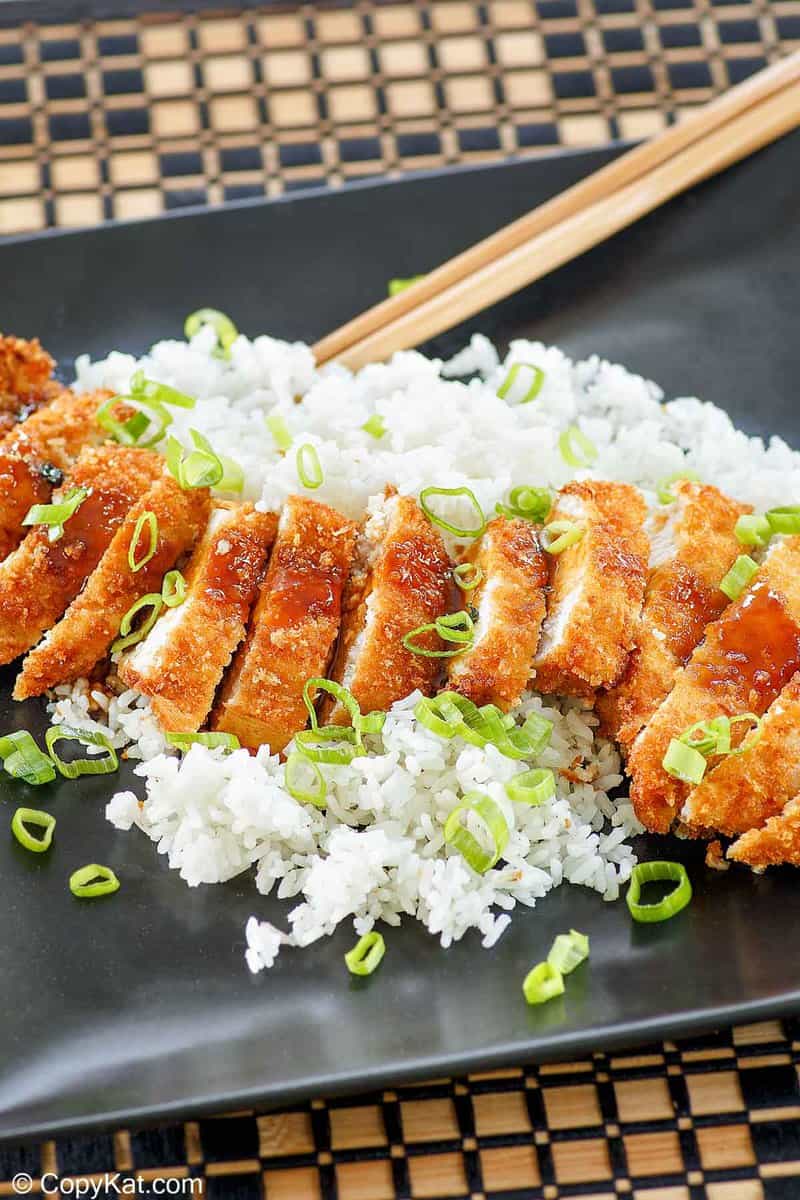chicken katsu with tonkatsu sauce and white rice on a platter.
