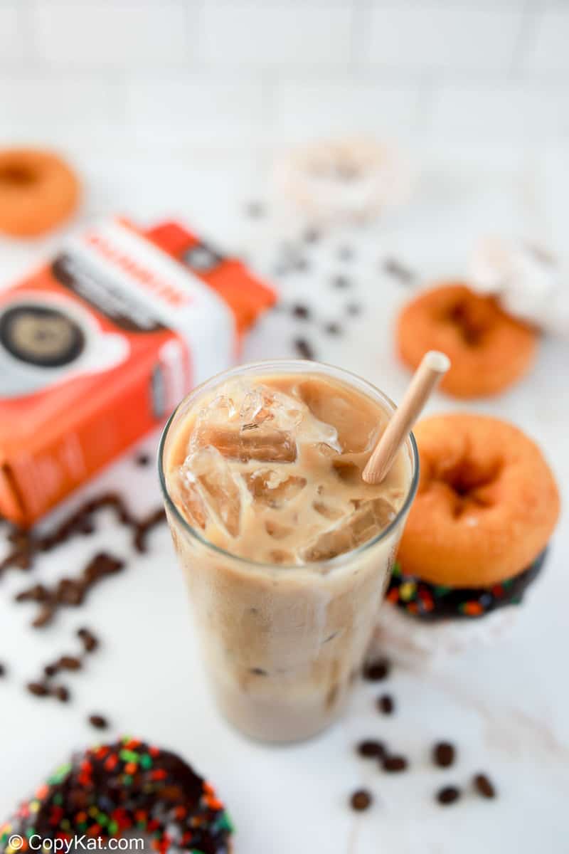 homemade Dunkin Donuts iced coffee, coffee beans, and donuts.