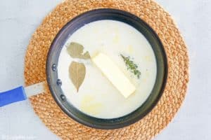 milk, butter, thyme sprigs, and bay leaves in a pan.