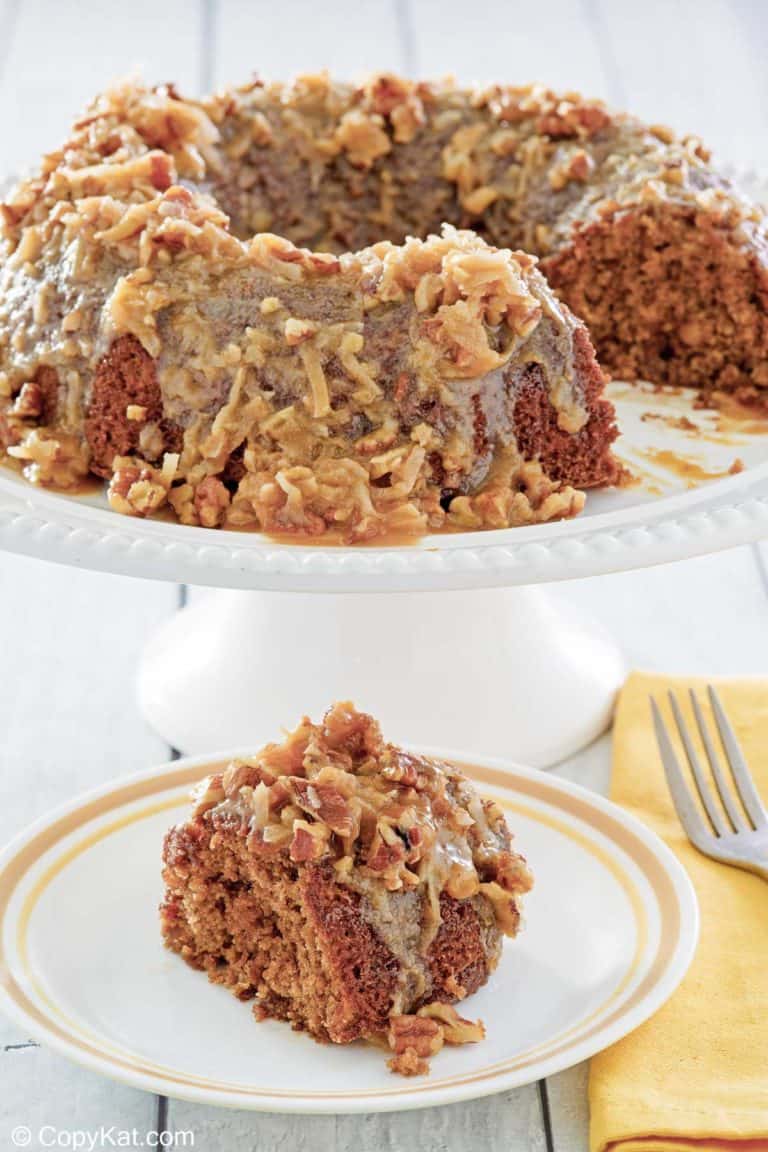 oatmeal cake with coconut pecan frosting on a cake stand and a slice on a plate.