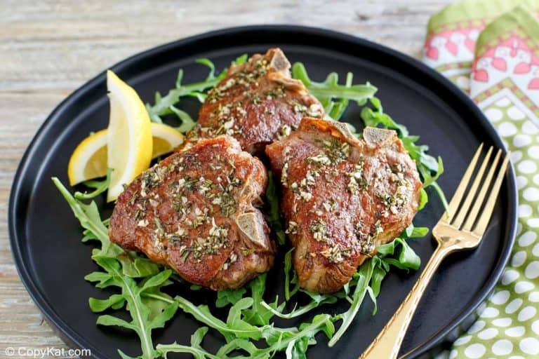Juicy pan-seared lamb chops with herbs on a plate.