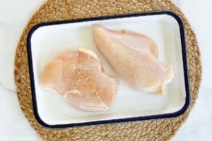 salted chicken breasts in a dish.