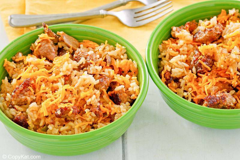 two bowls of sausage and rice casserole and two forks.