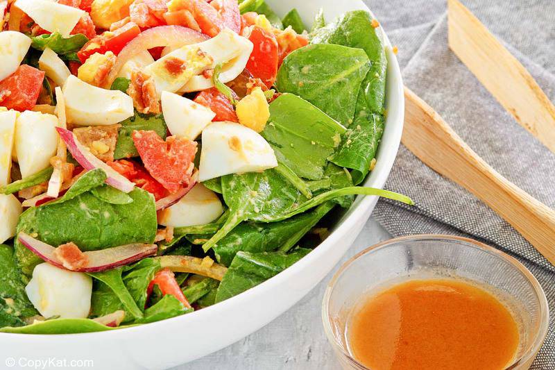 spinach salad and a small bowl of hot bacon dressing.