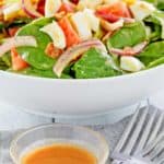 hot bacon dressing in front of a spinach salad.