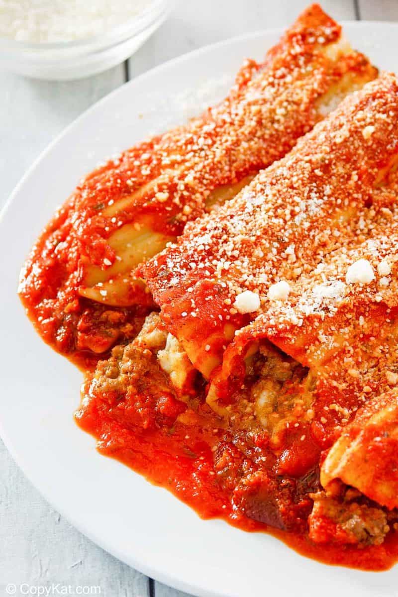 meat and cheese stuffed manicotti with sauce and romano cheese.