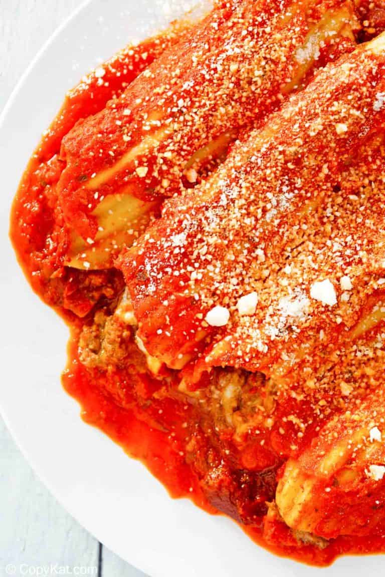 closeup of meat and cheese stuffed manicotti with sauce.