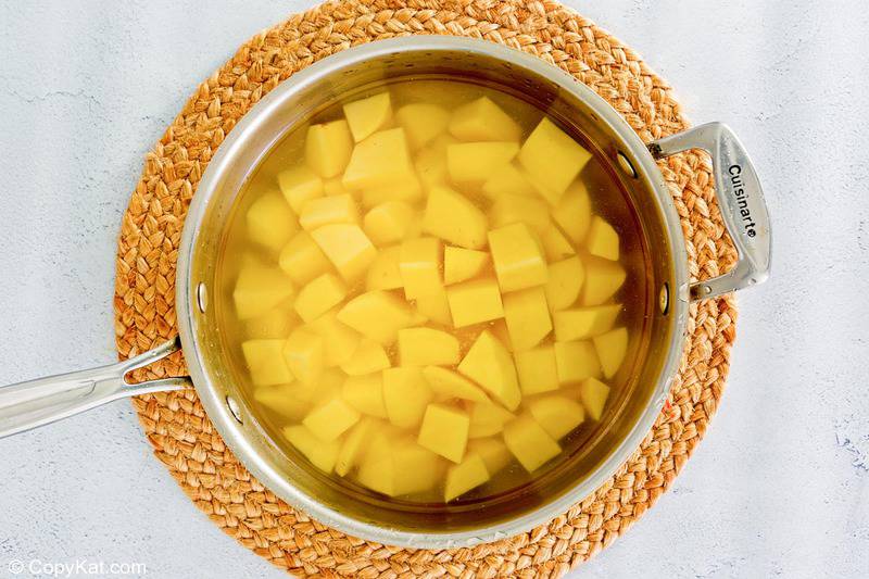 yukon gold potato cubes and water in a pan.