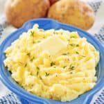 yukon gold mashed potatoes in a serving dish and three potatoes.